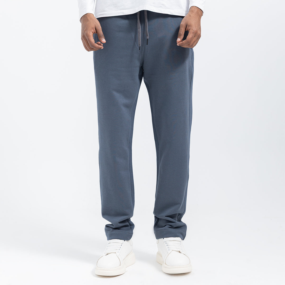 Person wearing gray sweatpants on a white background